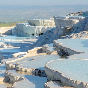 The enchanting pools of Pamukkale in Turkey. Pamukkale contains hot springs and travertines, terraces of carbonate minerals left by the flowing water. The site is a UNESCO World Heritage Site.